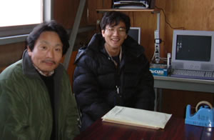 写真�E：贈られたパソコンの前で語る代表の杉浦さん（左）と事務局長の小山 隆太郎さん